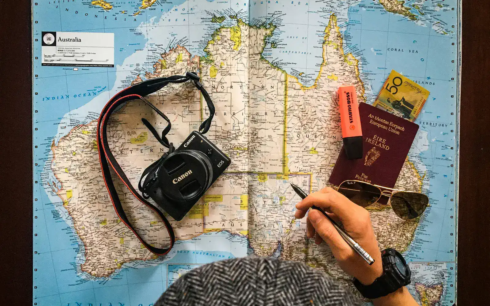 Mapa de viagem com câmara, passaporte e notas de planeamento representando uma proposta de viagem complexa